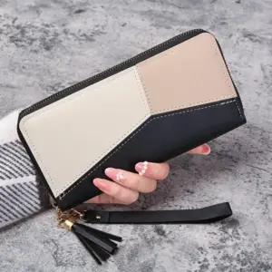 Lange Geldbörse mit Reißverschluss in Schwarz, Creme und Beige in der Hand gehalten
