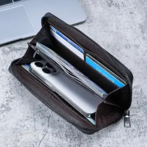 Aufgeklappte schwarze Reißverschluss-Geldbörse mit Kartenfächern, Scheinen und Smartphone
