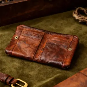 Braunes Leder-Portemonnaie in Used-Optik mit zwei Druckknöpfen auf grünem Samt