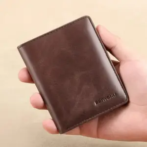 Braunes schmales Lederportemonnaie im Hochformat in der Hand gehalten